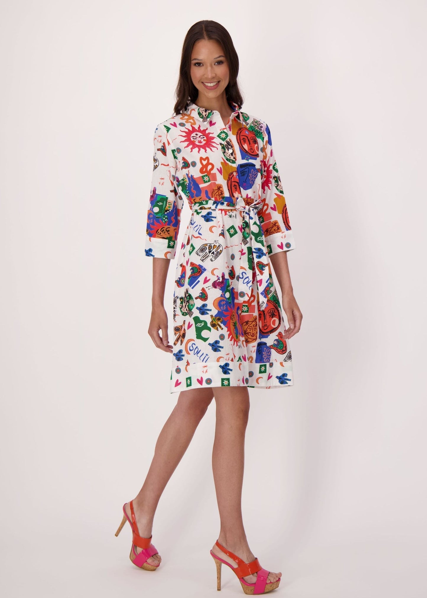 Woman wearing a colorful sun and moon abstract print dress on a white background