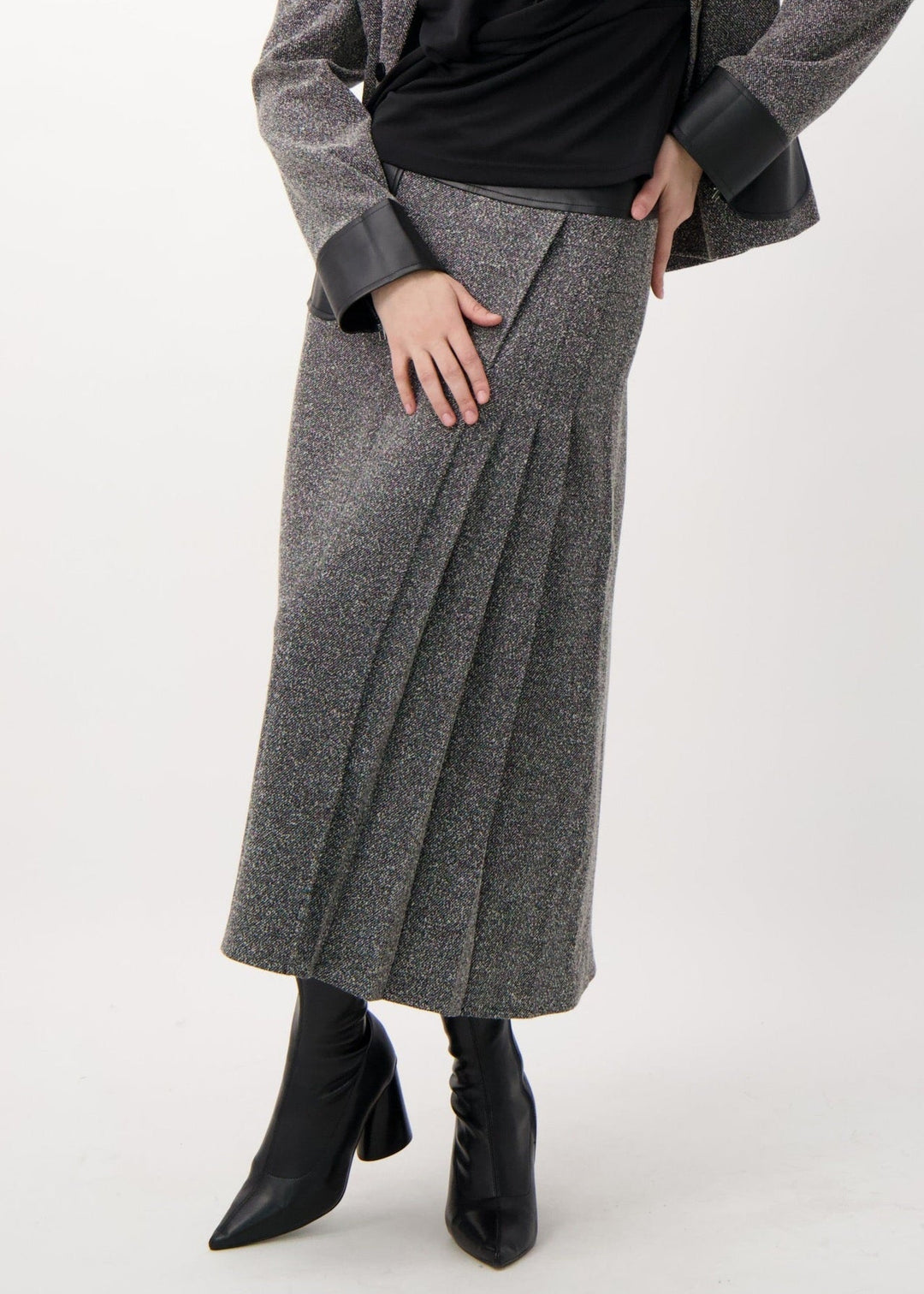 Woman wearing a gray coat and black top on a white background