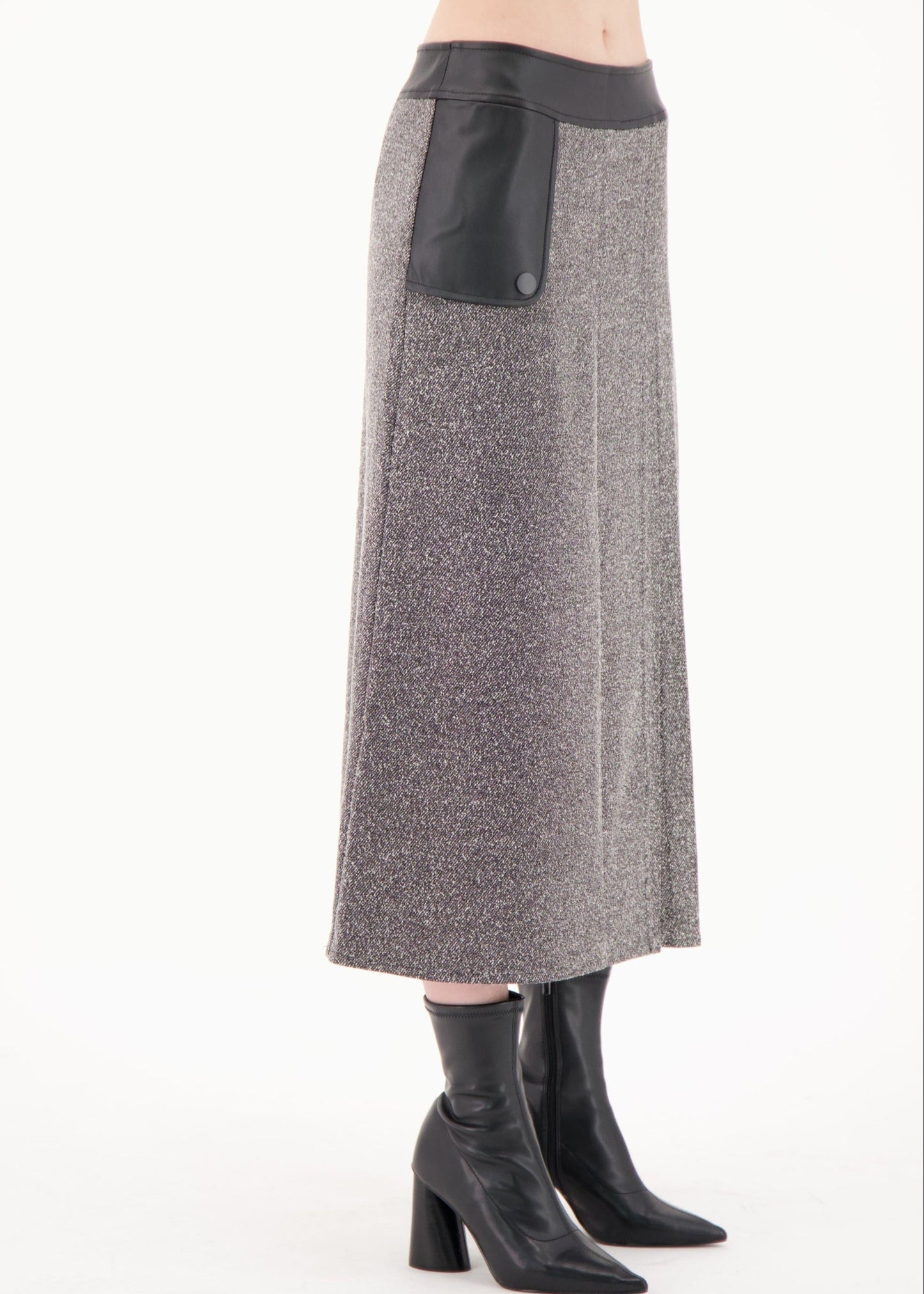 Gray skirt with black leather patch worn by a person on a white background