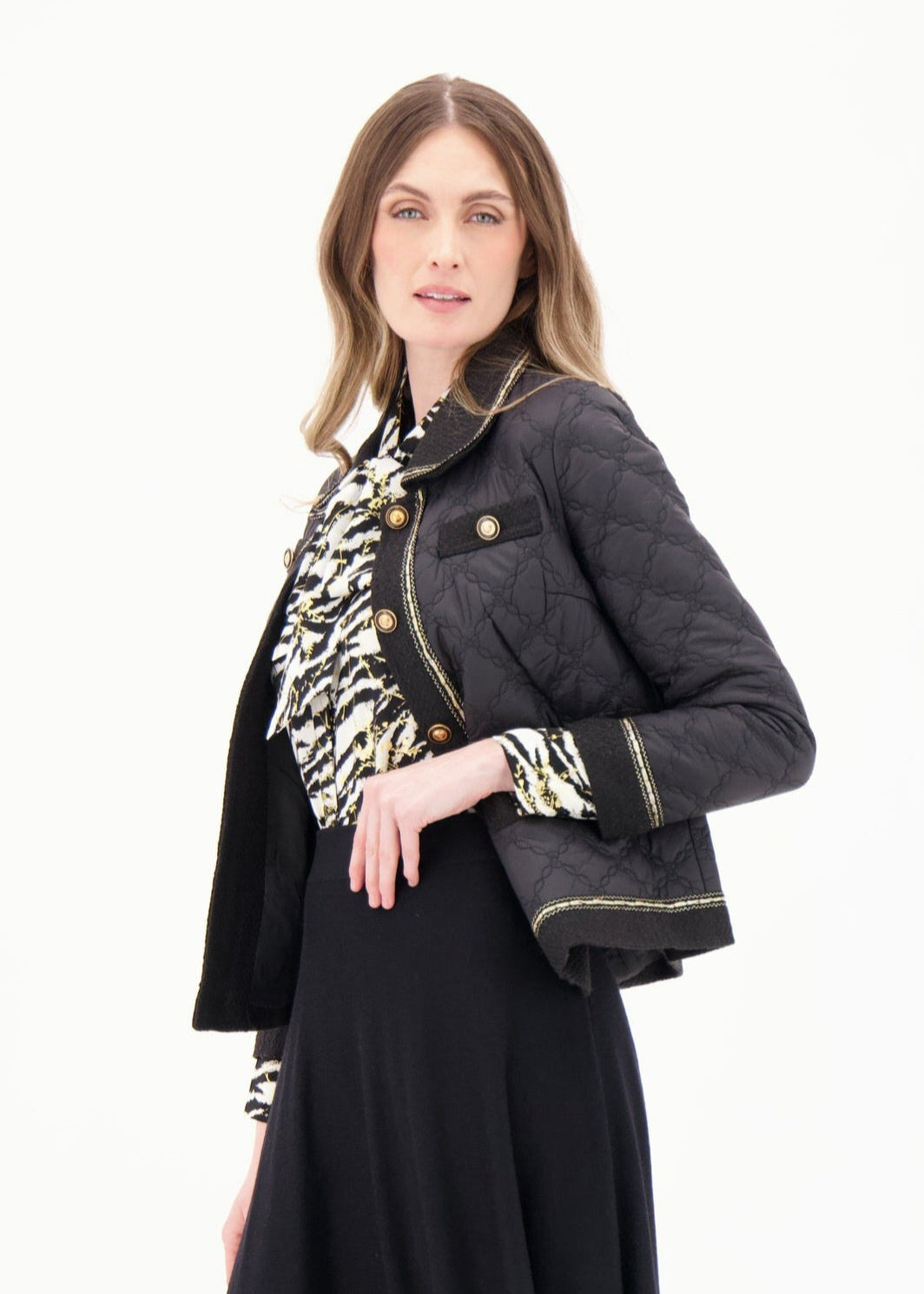 Woman wearing a black jacket, black skirt, and black boots on a white background